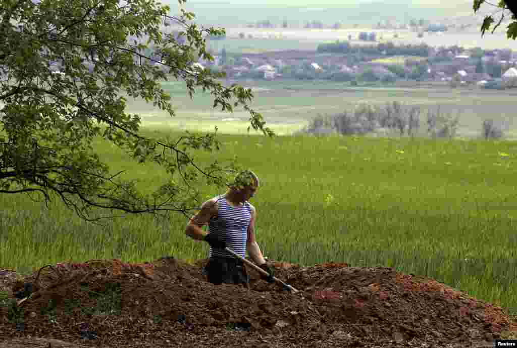 A Ukrainian soldier digs a trench outside the village of Bylbasivka near the eastern Ukrainian town of Slovyansk, May 15, 2014.