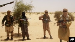 Ansar Dine fighters stand guard during hostage handover, outside Timbuktu, Mali, April 24, 2012.