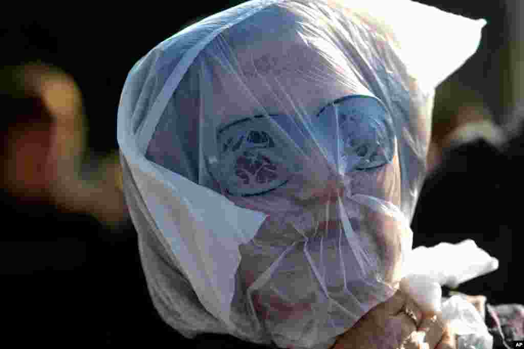 A protester covers her head in a plastic bag, meant to show that austerity measures are suffocating Greeks, outside Parliament in Athens, November 14, 2012. 