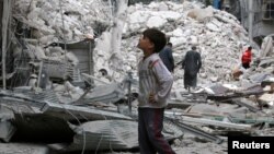 A boy inspects a damaged site after airstrikes on the rebel-held Tariq al-Bab neighbourhood of Aleppo, Syria, Sept. 23, 2016. 