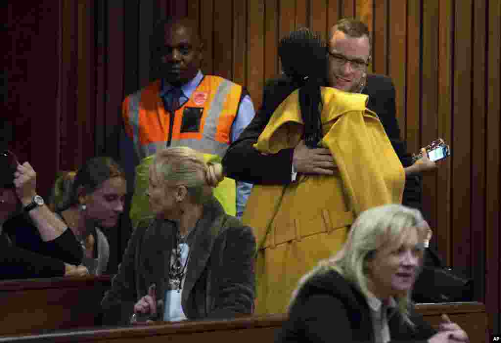 Oscar Pistorius is greeted by a supporter on his arrival in court for his murder trial in Pretoria, South Africa, May 13, 2014.