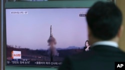 A man watches a TV report about North Korea's missile firing with file footage, at Seoul Train Station in Seoul, South Korea, April 6, 2017. The letters read "U.S., North, Scud missile-ER." 