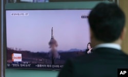 A man watches a TV report about North Korea's missile firing with file footage, at Seoul Train Station in Seoul, South Korea, April 6, 2017. The letters read "U.S., North, Scud missile-ER."