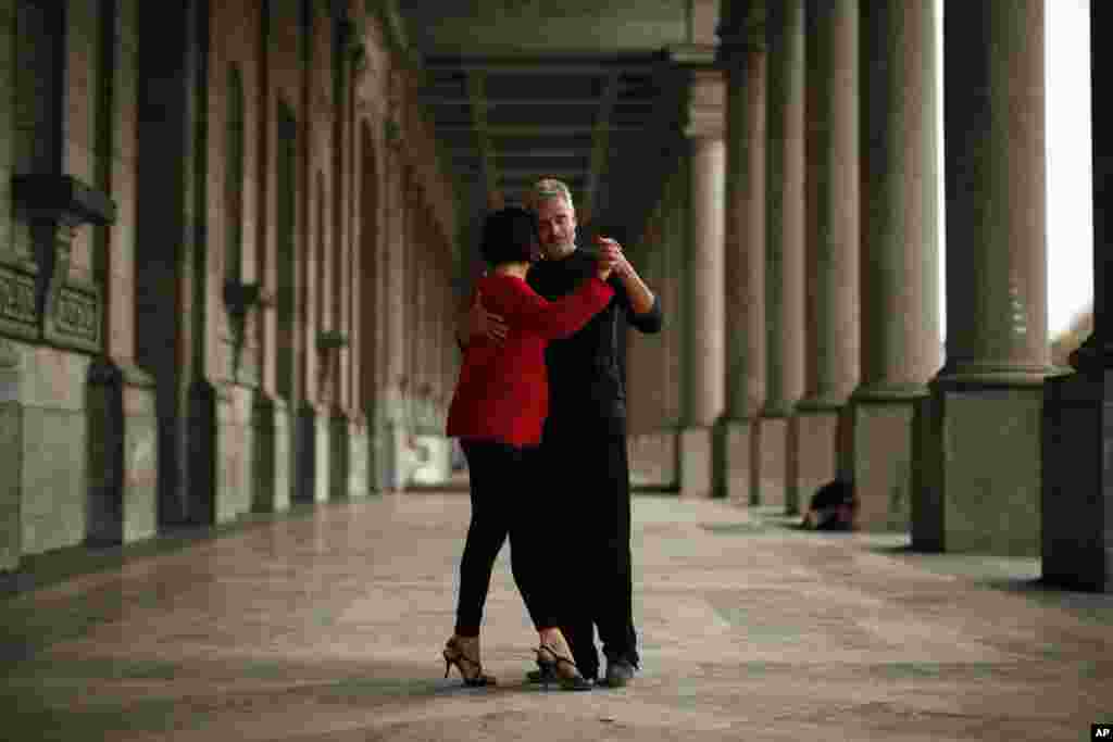 A couple dances on the arcade of the Royal Military museum at Cinquantenaire park in Brussels, Belgium.