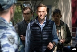 FILE - Russian opposition leader Alexei Navalny, center, arrives at court after his arrest during a protest in Moscow, Russia, May 11, 2018.