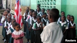 FILE - Liberian students are seen assembled to salute the flag at a Catholic school in the Liberian capital Monrovia.