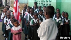 FILE - Liberian students are seen assembled to salute the flag at a Catholic school in the Liberian capital Monrovia.