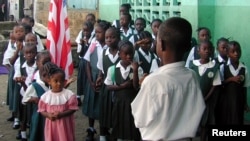 FILE - Liberian students are seen assembled to salute the flag at a Catholic school in the Liberian capital Monrovia.