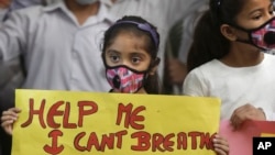 Seorang anak perempuan India memegang poster memprotes polusi udara di India, New Delhi, India, 6 November 2016. 