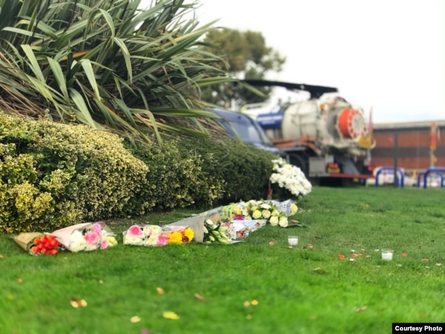 Hoa do người địa phương để lại phía đường đối diện chỗ chiếc xe đỗ sau khi phát hiện 39 người chết. (Hình: Nguyễn Hùng)