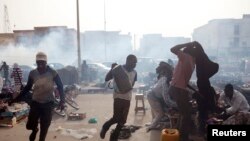 Men run from tear gas fired by police during an anti-slavery demonstration to demand the liberation of imprisoned abolitionist leader Biram Ould Abeid in Nouakchott, May 26, 2012.