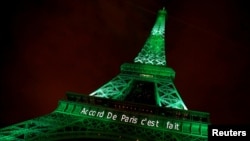 FILE - The Eiffel tower is illuminated in green with the words "Paris Agreement is Done," to celebrate the Paris U.N. Climate Change agreement in Paris, France, Nov. 4, 2016.