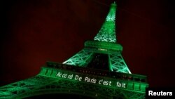 FILE - The Eiffel tower is illuminated in green with the words "Paris Agreement is Done," to celebrate the Paris U.N. Climate Change agreement in Paris, France, Nov. 4, 2016. While U.S. President Donald Trump has since expressed opposition to the agreement, Syria has joined the pact.
