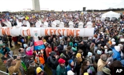 Protestors gather at the National Mall in Washington calling on President Barack Obama to reject the Keystone XL oil pipeline from Canada, as well as act to limit carbon pollution from power plants and “move beyond” coal and natural gas, Feb. 17, 2013.