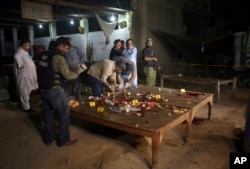 Pakistani investigators collect evidence from the site of a shooting in Karachi, Pakistan, June 23, 2017. Gunmen in the port city of Karachi attacked police officers at a roadside restaurant and killed four of them before fleeing, according to senior poli