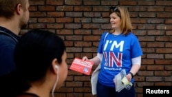 FILE - A woman campaigns in London, May 20, 2016, for Britain to stay in the European Union. The World Trade Organization’s leader warns that a June 23 vote supporting Brexit could harm Britain’s economy.