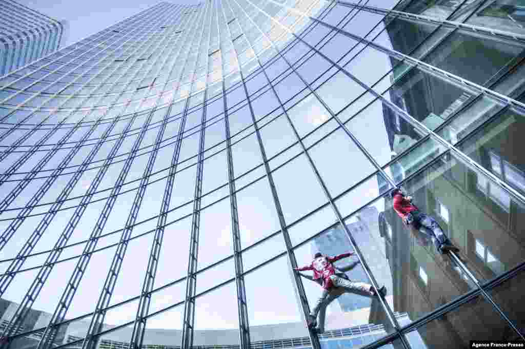 "Fransız hörümçək adamı" kimi tanınan fransız şəhər alpinistləri Alain Robert (solda) və Leo Urban Almaniyanın Frankfurt şəhərində 153,8 metr hündürlüyündə SKYPER Tower binasına qalxırlar