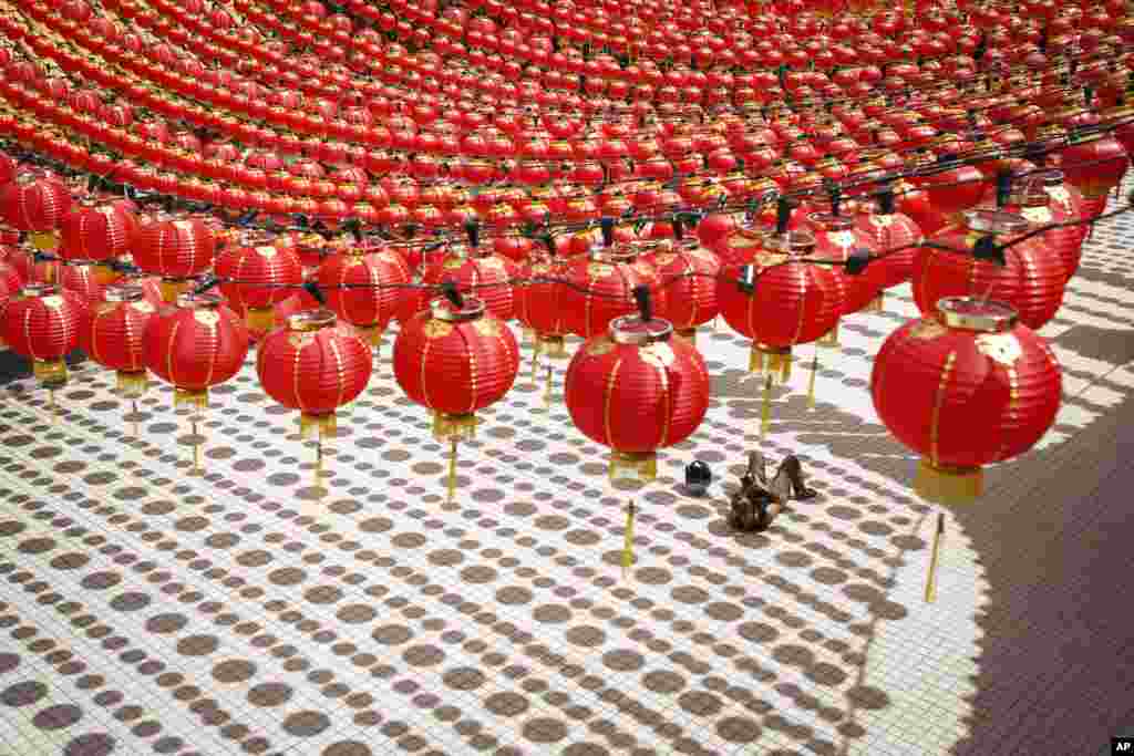 A tourist lies on the floor cast with shadows of traditional Chinese lanterns ahead of the Lunar New Year celebrations in Kuala Lumpur, Malaysia.