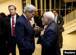 U.S. Secretary of State John Kerry talks with Iranian Foreign Minister Javad Zarif after the International Atomic Energy Agency (IAEA) verified that Iran has met all conditions under the nuclear deal, in Vienna January 16, 2016.