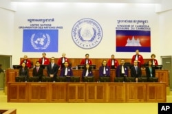 FILE - In this photo released by the Extraordinary Chambers in the Courts of Cambodia, judges and clerks of the U.N.-backed war crimes tribunal stand inside the court hall of a U.N.-backed war crimes tribunal in Phnom Penh, Cambodia, Thursday, Aug. 7, 2014.