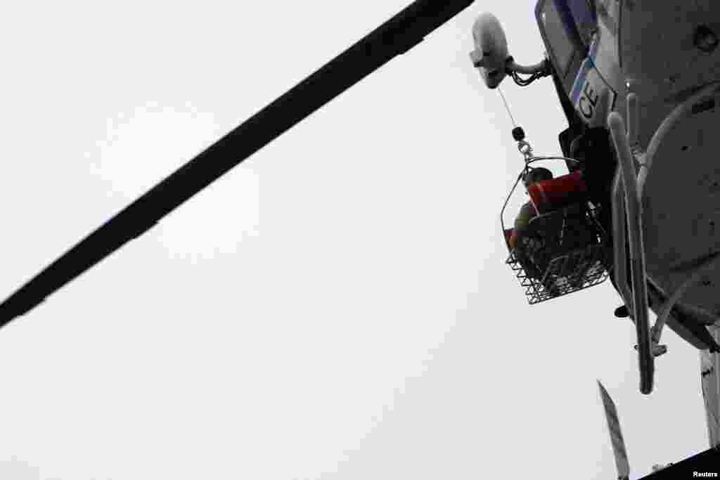 A helicopter pulls what appears to be a shooting victim up as it hovers over a rooftop on the Washington Navy Yard, Sept. 16, 2013. 