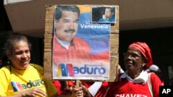 Supporters of Venezuela's President Nicolas Maduro hold a poster of him outside the Supreme Court where he is being sworn-in for another term in Caracas, Venezuela, Thursday, Jan. 10, 2019. 