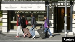 Asian tourists walk past a luxury watch shop in the Swiss alpine resort Interlaken, Switzerland, Nov. 17, 2015. Europe's travel industry could lose over $1 billion in revenues because of the impact of the Paris attacks, analysts say.