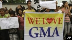 Supporters of former Philippine President Gloria Macapagal Arroyo hold candles during a rally outside the Veterans Memorial Medical Center where she is now under police custody, Manila, Oct. 4, 2012.