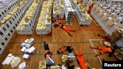 FILE - Workers lay during a break as they prepare election materials before their distribution to polling stations in a warehouse in Jakarta, Indonesia, April 15, 2019. 
