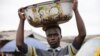 A man balances a bowl with a print of the old Nigerian naira banknote on his head at a local market in Agege district in Lagos, Nigeria, Aug. 16, 2016.