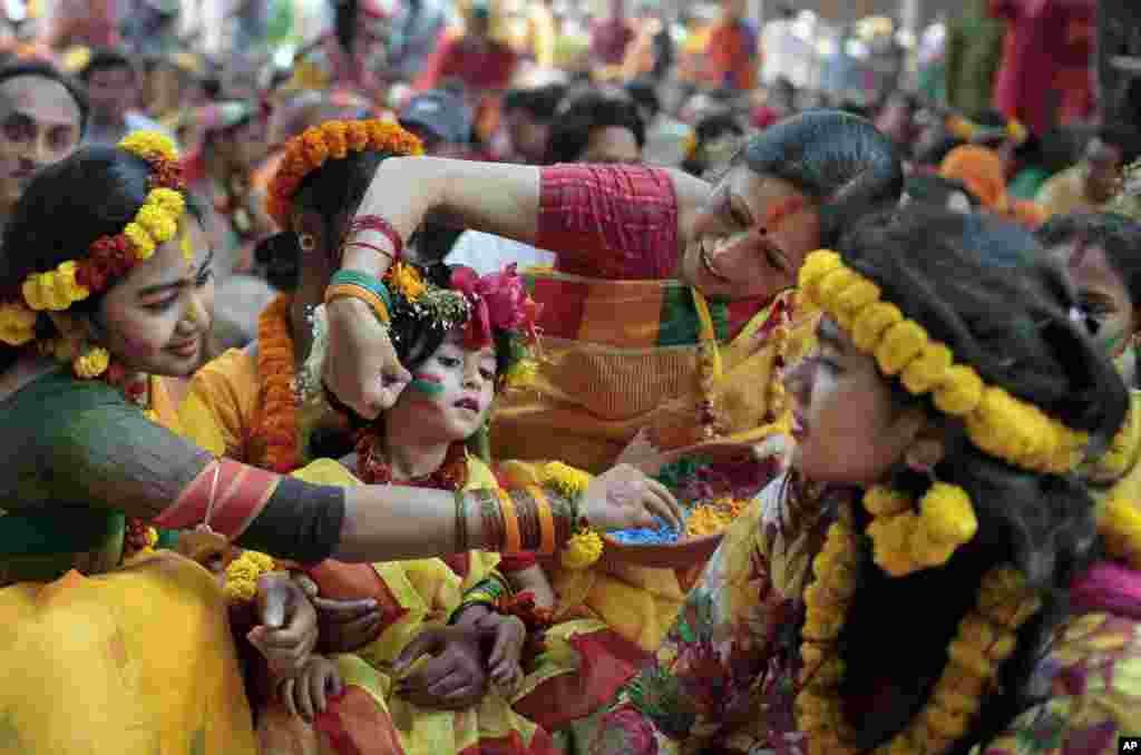 Bangladeshi girls put vermillion powder on each other as they celebrate the arrival of spring on the first day of Falgoon at the Dhaka University campus in Dhaka, Bangladesh. Falgoon is the 11th month on the Bengali calendar.