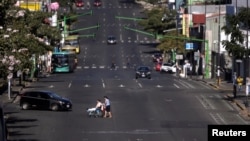 Personas cruzan una calle casi vacía en San José, Costa Rica, luego que el gobierno anunció medidas de prevención por el coronavirus. Marzo 15 de 2020.