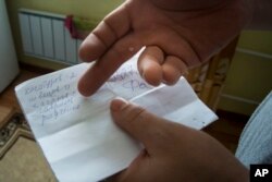 Yevgeny Berdyshev shows a list that residents of the village have compiled of the locals who are fighting in Syria, in Kedrovoye, Russia, Feb. 15, 2018.