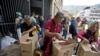 En esta imagen del 6 de julio de 2018, empleados de un centro cultural gestionado por el gobierno reciben las cajas con alimentos subsidiados distribuidas bajo el programa gubernamental "CLAP" , en el centro de Caracas, Venezuela. (AP Foto/Fernando Llano, Archivo)