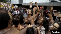 FILE - Environmental activists chant slogans during a protest in front of the headquarters of Brazilian mining company Vale SA in downtown Rio de Janeiro, Nov. 16, 2015. 