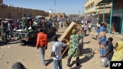 Malian troops try to dissuade the crowd from looting shops in Timbuktu, Jan. 29, 2013. Hundreds of Malians looted Arab-owned shops Tuesday in Mali's fabled Timbuktu, newly freed from Islamists.