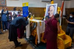 Presiden Administrasi Pusat Tibet Penpa Tsering, meletakkan syal upacara di depan potret pemimpin spiritualnya Dalai Lama dalam upacara untuk menandai ulang tahun ke-86 pemimpin Tibet di Dharmsala, India, Selasa, 6 Juli 2021. (AP)