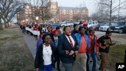 Mahasiswa Universitas Oklahoma(10/3) berbaris menuju asrama Sigma Alpha Epsilon di Norman, Oklahoma, yang kini ditutup (AP Photo/Sue Ogrocki).