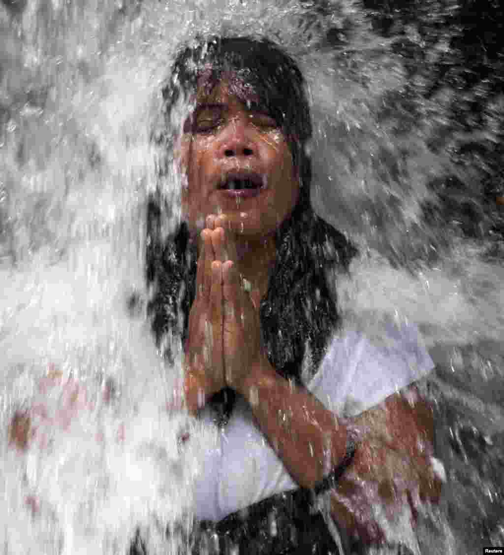 A Balinese Hindu devotee bathes in the Sebatu waterfall during a &quot;Melukat&quot; purification ritual in Gianyar District in Bali, Indonesia.