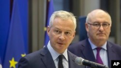 French Finance Minister Bruno Le Maire, left, and European Trade Commissioner Phil Hogan attend a media conference after their meeting in Paris, Jan. 7, 2020.