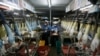 FILE - Workers collect rubber gloves at Top Glove's factory in Klang, outside Kuala Lumpur.