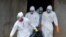 Medical workers of the Liberian Red Cross, wearing a protective suit, carry the body of a victim of the Ebola virus in a bag on Sept. 4, 2014 in the small city of Banjol, 30 kilometers from Monrovia. 