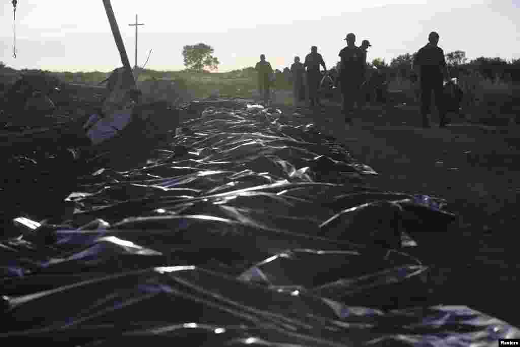 Members of the Ukrainian Emergencies Ministry gather the remains of victims at the crash site of Malaysia Airlines Flight MH17 near the village of Hrabove, Donetsk region, eastern Ukraine, July 20, 2014.