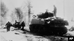 FILE - U.S. tanks move in the snow and ice from the town of Tri-le-Cheslaing, Belgium, on Jan. 7, 1945 during the Battle of the Bulge in World War II. Robbie Edmonds, taken prisoner during the battle, refused to separate Jewish POWs from the other America