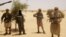 Ansar Dine fighters stand guard during hostage handover, outside Timbuktu, Mali, April 24, 2012.