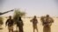 Fighters from Islamist group Ansar Dine stand guard during a hostage handover, in the desert outside Timbuktu, Mali, April 24, 2012.