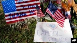 A memorial for U.S. Capitol Police officer Brian Sicknick is visible near the Capitol Building on Capitol Hill in Washington, Thursday, Jan. 14, 2021. Sicknick was killed by rioters in last Wednesday's attack on the Capitol Building. (AP Photo…