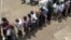 FILE – Voters line up at a polling station in Kampala, Uganda, in February 2011, as they wait to cast their ballot. 