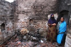Two Muslim women survey their room, which was set aflame by a Hindu mob during violence in Telinipara, West Bengal, on May 12. Attackers doused the room with petrol before setting it alight. (Shaikh Azizur Rahman/VOA)