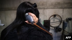 FILE - A visitor tries out installations set up with a series of sound-producing devices and mechanisms at an exhibition entitled 'Iran's Sound Scene' in Tehran, on Feb. 4, 2025. 